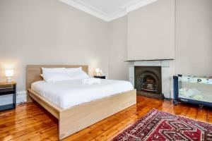 Schlafzimmer mit einem Bett, einem Kamin und einem TV in der Unterkunft Charming Fitzroy Retreat Art, Dining, Serenity in Melbourne