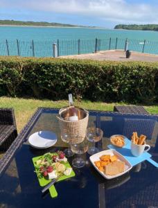 a table with food on it with a view of the ocean at Oyster Bay Holiday Apartment Dundrum in Dundrum