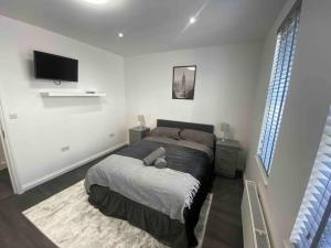 een slaapkamer met een bed en een flatscreen-tv bij LONDON STAY Flats in Londen