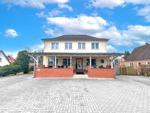 a large white house with a brick driveway at BesTime - 5 Schlafzimmer, Wohnzimmer, Küche, Waschtrockner, Terrasse, Smart-TVs, Netflix, Tischfußball in Wildeshausen