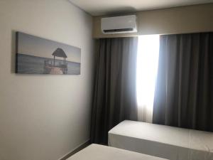 a bedroom with a bed and a picture of the ocean at Apto Thermas Resort São Pedro in São Pedro