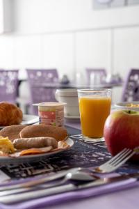 een tafel met een bord eten en een glas sinaasappelsap bij Hôtel - Restaurant Saint Jacques in Blois