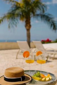 帕福斯的住宿－Amazing Villa with panoramic sea view，一张桌子,上面放着两杯橙汁和一盘水果