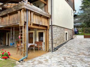 - un bâtiment en bois avec une table et des chaises sur une terrasse dans l'établissement Apartmány Chalupinka, à Železná Ruda