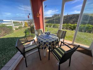 uma mesa e cadeiras num pátio com vista para o oceano em Costa Comillas Villa Rosa em Comillas