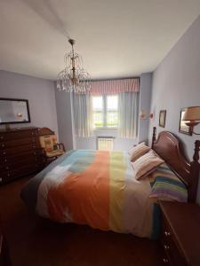 um quarto com uma cama com um cobertor colorido em Costa Comillas Villa Rosa em Comillas