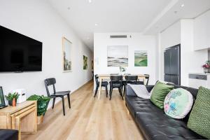 uma sala de estar com um sofá preto e uma mesa em Stylish Urban Retreat with Spectacular Views and Prime Location em Melbourne