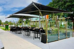 a restaurant with tables and chairs under a black umbrella at Stylish Urban Retreat with Spectacular Views and Prime Location in Melbourne