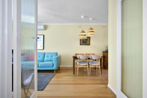 a living room with a blue couch and a table at Ocean Blue Haven Beachside 2-Bed Unit in Hampton in Melbourne