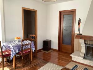 sala de estar con mesa, TV y puerta en Casita acogedora en el centro del pueblo en Porriño