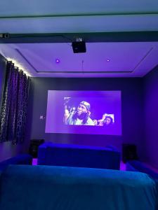 Zimmer mit einem großen Bildschirm mit violetten Lichtern in der Unterkunft Nanani Villa - Harmonious Paradise in Kumasi