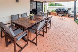 a wooden table and chairs on a patio at Seaside Serenity at Plumeria Place in Brisbane