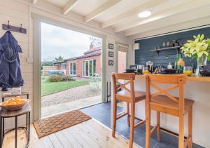 a kitchen with a table and two chairs and a counter at The Bollard at the Anchorage in Sculthorpe