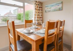 een eetkamer met een houten tafel en stoelen bij LAmourette in Bacton