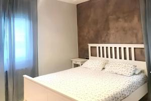 um quarto com uma cama branca e uma janela em 4 bedrooms villa with private pool furnished terrace and wifi at Calonge em Calonge
