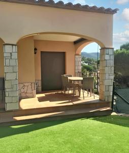 um pátio com uma mesa e cadeiras num relvado em 4 bedrooms villa with private pool furnished terrace and wifi at Calonge em Calonge