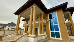 a house with large windows and columns at Nanani Villa - Harmonious Paradise in Kumasi