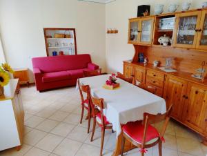 a living room with a table and a red couch at Casa Mimosa - appartamento vacanze sul Lago di Como in Sorico