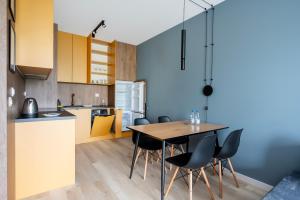 a kitchen and dining room with a table and chairs at Wieniawskiego Chic Apartment in Łódź