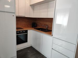 uma cozinha branca com um lavatório e um fogão em Apartmani Sanja em Teslic