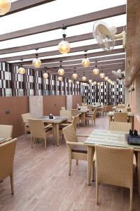 a dining room with tables and chairs and lights at HOTEL DEVA INN in Varanasi