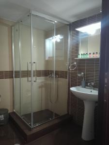 a bathroom with a glass shower and a sink at Seacoast apartments 3 ! in Kamena Vourla