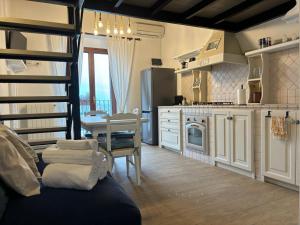 eine Küche mit weißen Schränken und einer Wendeltreppe in der Unterkunft Il Palazzino in Taranto