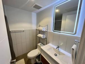 a bathroom with a toilet and a sink and a mirror at Medju - Elegant Apartment in Guatemala