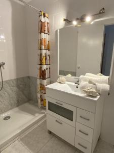 La salle de bains blanche est pourvue d'un lavabo et d'un miroir. dans l'établissement Apartamento con Feng Shui, à Calafell