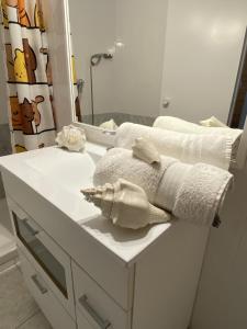 La salle de bains est pourvue d'un lavabo, de serviettes et d'un miroir. dans l'établissement Apartamento con Feng Shui, à Calafell