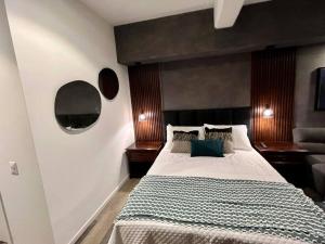 een slaapkamer met een groot bed met een zwart hoofdeinde bij Medju - Elegant Apartment in Guatemala