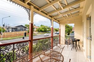 a balcony with chairs and a view of a street at Modern 2BR in Ashgrove in Brisbane