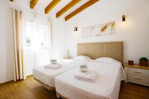two beds in a bedroom with white sheets and a window at I - St. Johns Countryside Getaway in Odiáxere