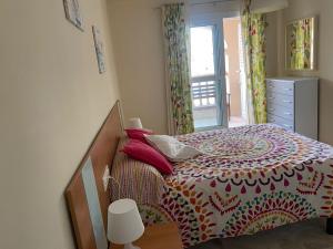 a bedroom with a bed with a colorful bedspread at Apartamento Portofino Sun & Beach in Almerimar