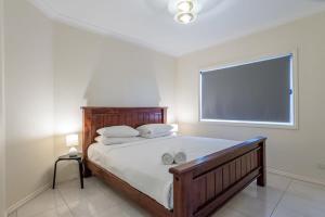 a bedroom with a large bed with a large window at Modern Victorian Holiday Home in Ashgrove in Brisbane