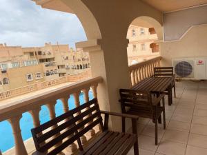 a balcony with benches and a view of the water at Apartamento Portofino Sun & Beach in Almerimar