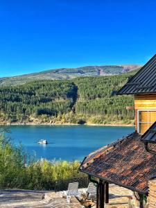 a house with a view of a lake with a boat at Zavojsko jezero - Vila Jezero in Pirot