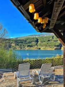 two chairs on a patio with a view of a lake at Zavojsko jezero - Vila Jezero in Pirot