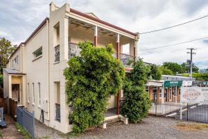 a building with a large bush in front of it at Modern 2BR With Deck in Brisbane