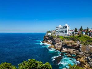 a building on a cliff next to the ocean at Clifftop Oasis with Breathtaking Views in Sydney