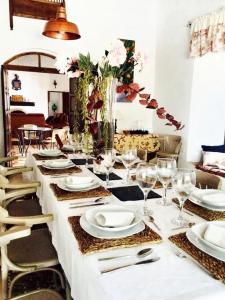 a table with plates and glasses and a vase with flowers at 7 bedrooms villa with private pool enclosed garden and wifi at Cordoba in Córdoba
