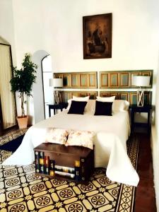 Un dormitorio con una gran cama blanca y una mesa en 7 bedrooms villa with private pool enclosed garden and wifi at Cordoba, en Córdoba