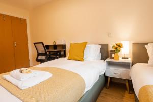 a bedroom with two beds and a desk with a chair at Updated & central 2 bedroom Chester apartment - for up to 6 in Chester