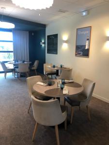 um restaurante com mesas e cadeiras num quarto em Logis Hôtel Lucotel em Lanvollon