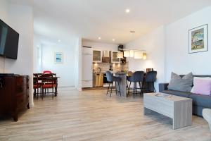 a living room with a blue couch and a kitchen at Haus Ahlbeck in Ahlbeck