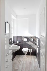 a white bathroom with a sink and a toilet at Haus Ahlbeck in Ahlbeck