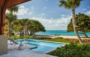 a swimming pool with a view of the beach at Oil Nut Bay in Virgin Gorda