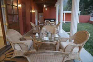 Summer House Nandi Foothills في Nandi: مجموعة من الطاولات والكراسي على الفناء