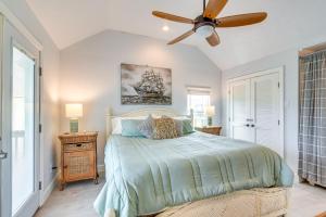 a bedroom with a bed with a ceiling fan at Lovely Crystal Beach House with Deck Walk to Ocean! in Crystal Beach