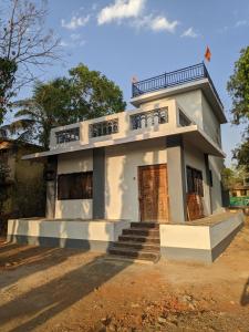 een klein wit huis met een trap ervoor bij White House at Bhadane Saralgaon in Saralgaon